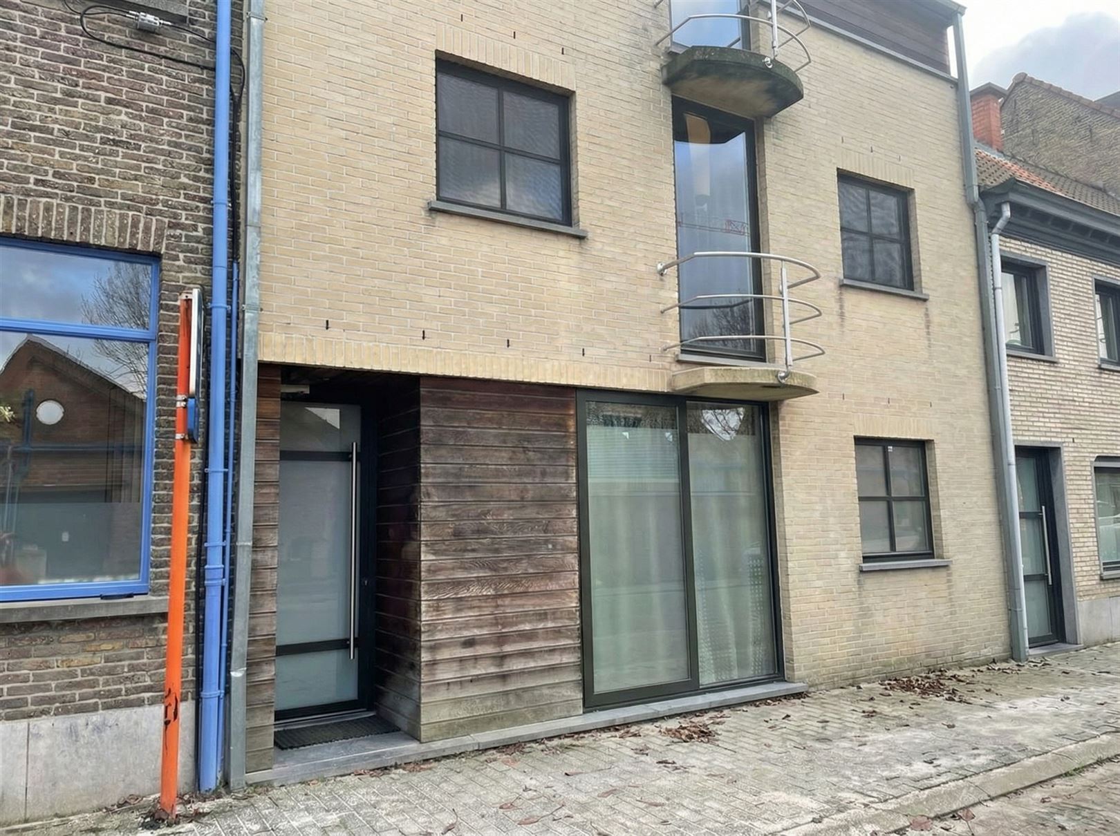 straat-voorkant-gebouw-met-parkeerplaatsen